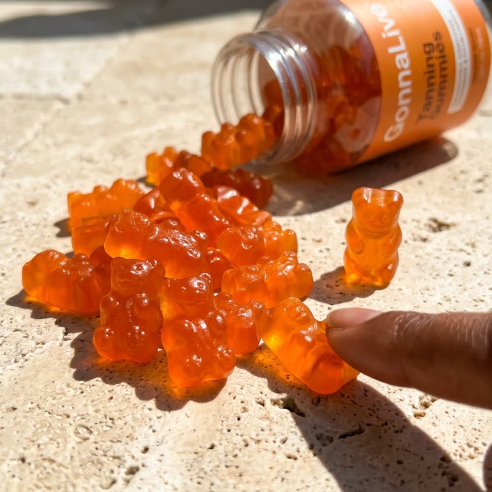 Orangefarbene GonnaLive Gummibärchen aus der geöffneten Dose auf warmem Stein